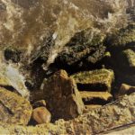 скала, внизу камни обрыв и вода